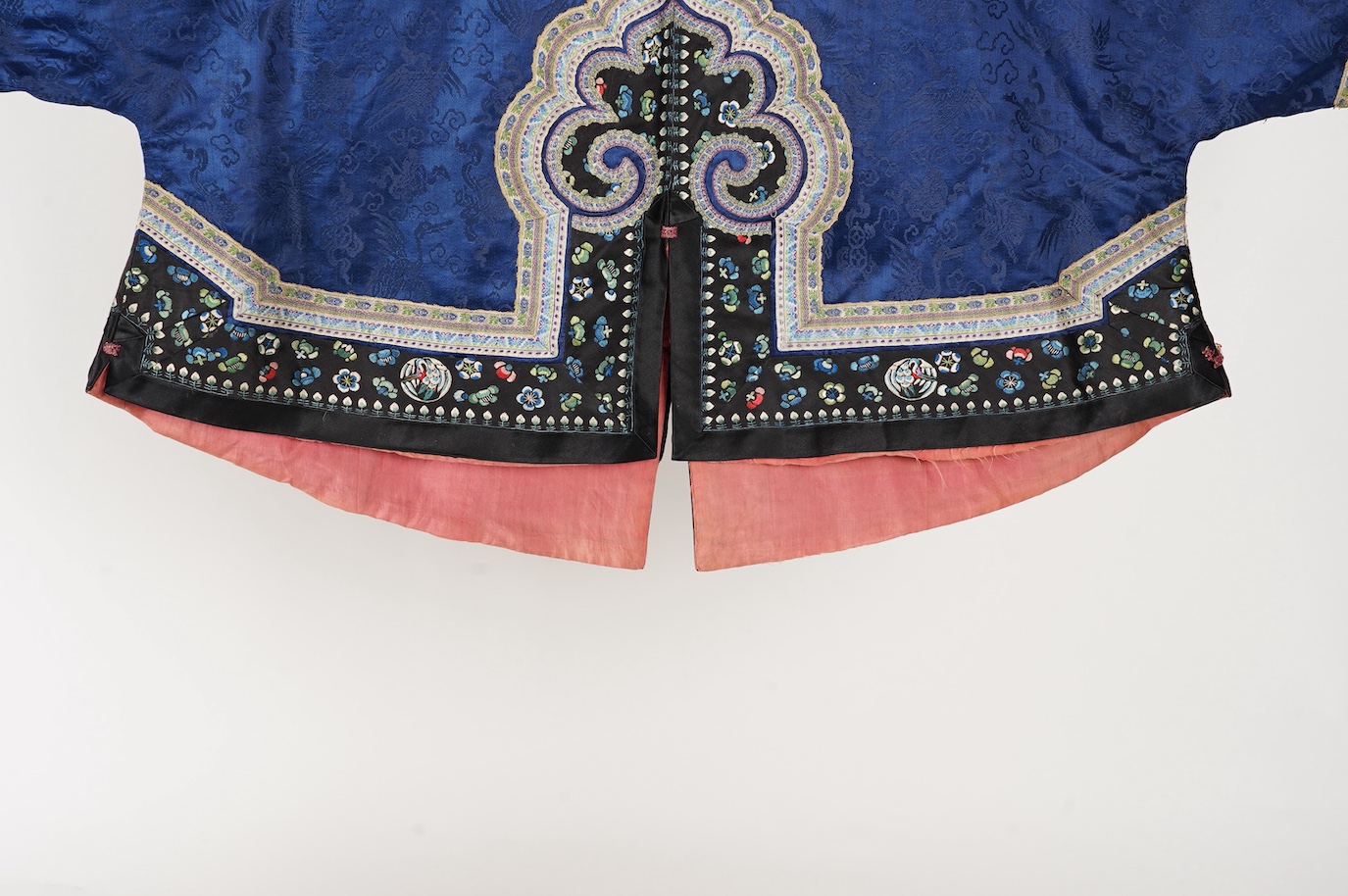 A late 19th century Chinese blue silk damask jacket, woven with Phoenix and auspicious symbols. The jacket edged with ornate rows of braiding and silk embroidery, the interior with original pink silk lining. The jacket f